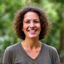 Sarah, a solo traveler, smiling brightly amidst lush Costa Rican rainforest