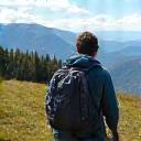 A solo hiker on a well-maintained trail, looking confident and prepared, with a distant, beautiful landscape, suggesting safety and preparedness for solo travel.